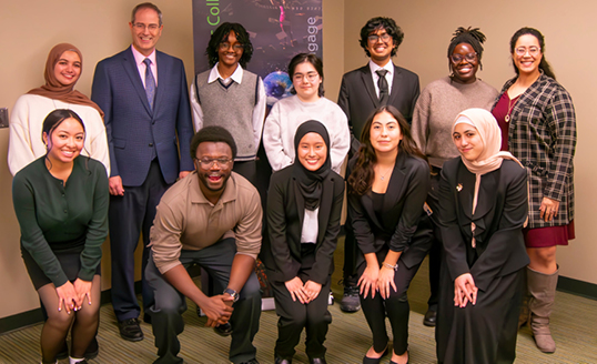 Twelve students participating in the Diversity Research Showcase pose for a photo