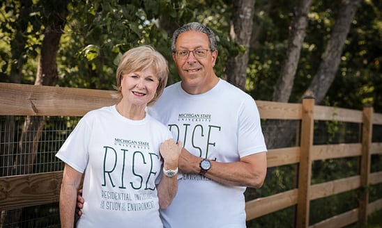 Gary and Sue Farha, both wearing white T-shirts that say Michigan State University RISE: Residential Initiative on the Study of the Environment