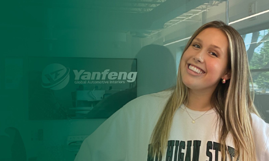 Maddie Ritsema poses in front of a Yanfeng sign