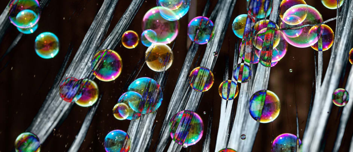 Brightly colored bubbles superimposed on a close-up image of straight strands of hair
